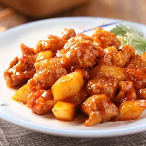 Sweet and sour pork with a glossy glaze and pineapples.