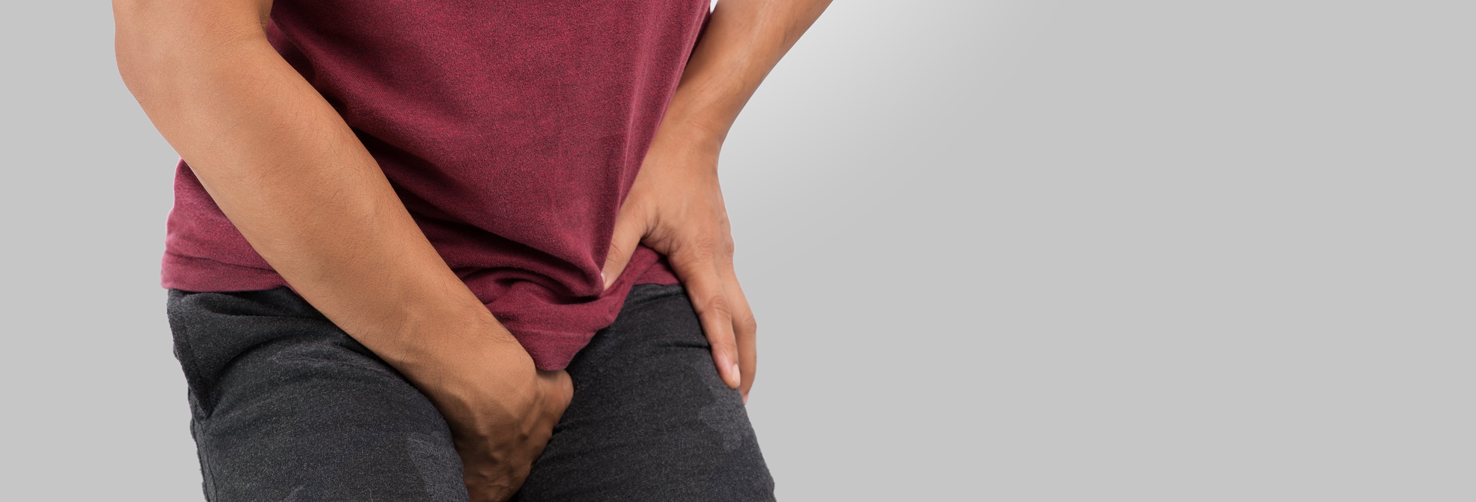 Man holding groin area indicating discomfort associated with jock itch 