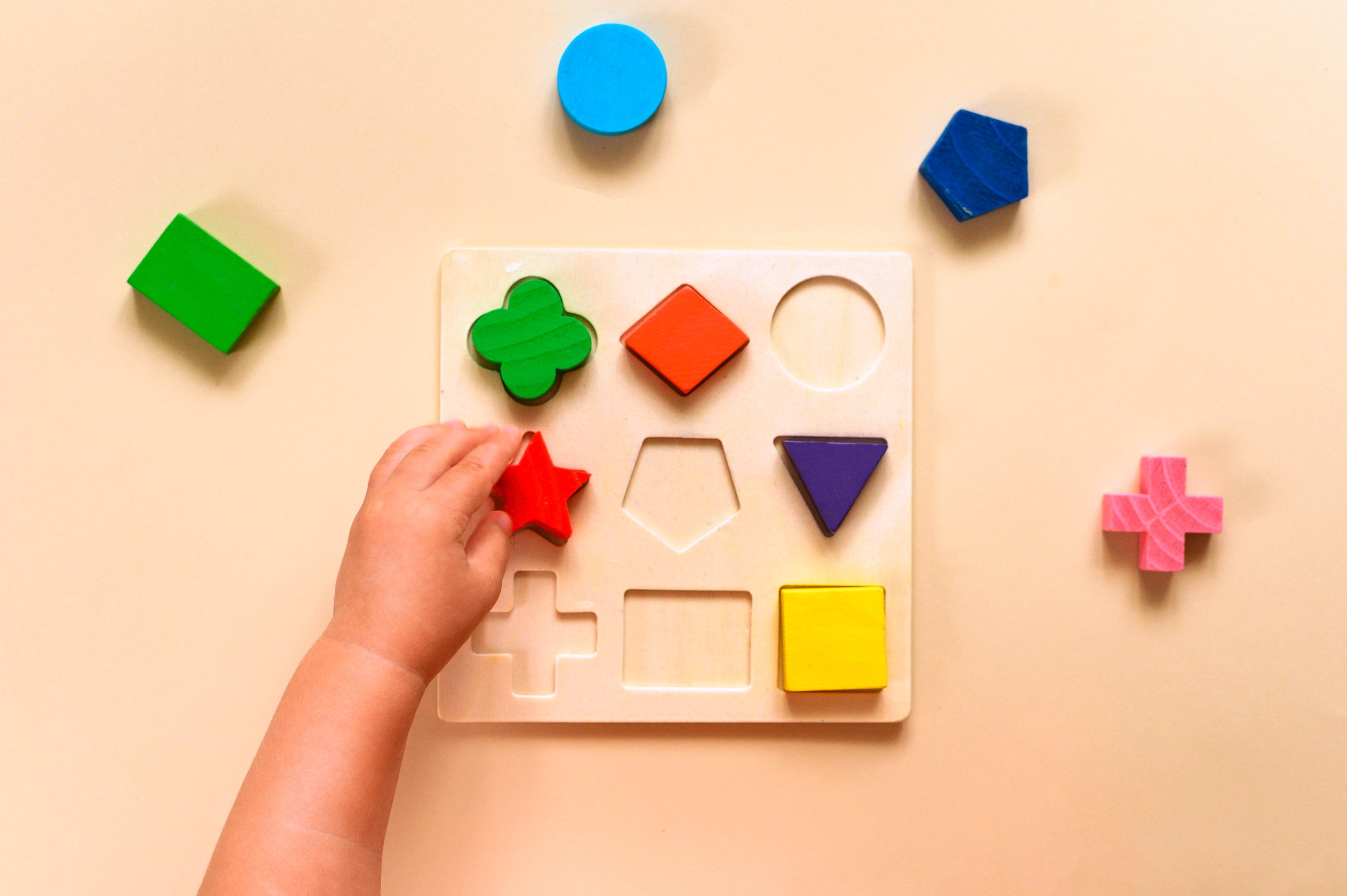 tangan anak-anak yang sedang bermain dengan shape sorter