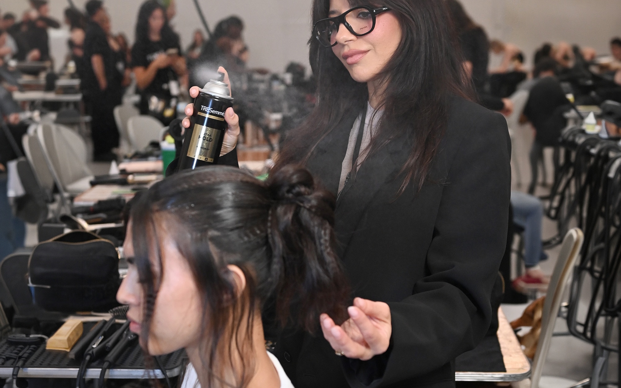 Hairstylist Justine Marjan spraying TRESemmé Extra Hold hairspray backstage at New York Fashion Week