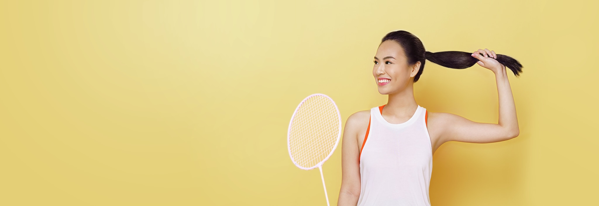 A woman with dark hair, smiling and lying down on wooden planks.