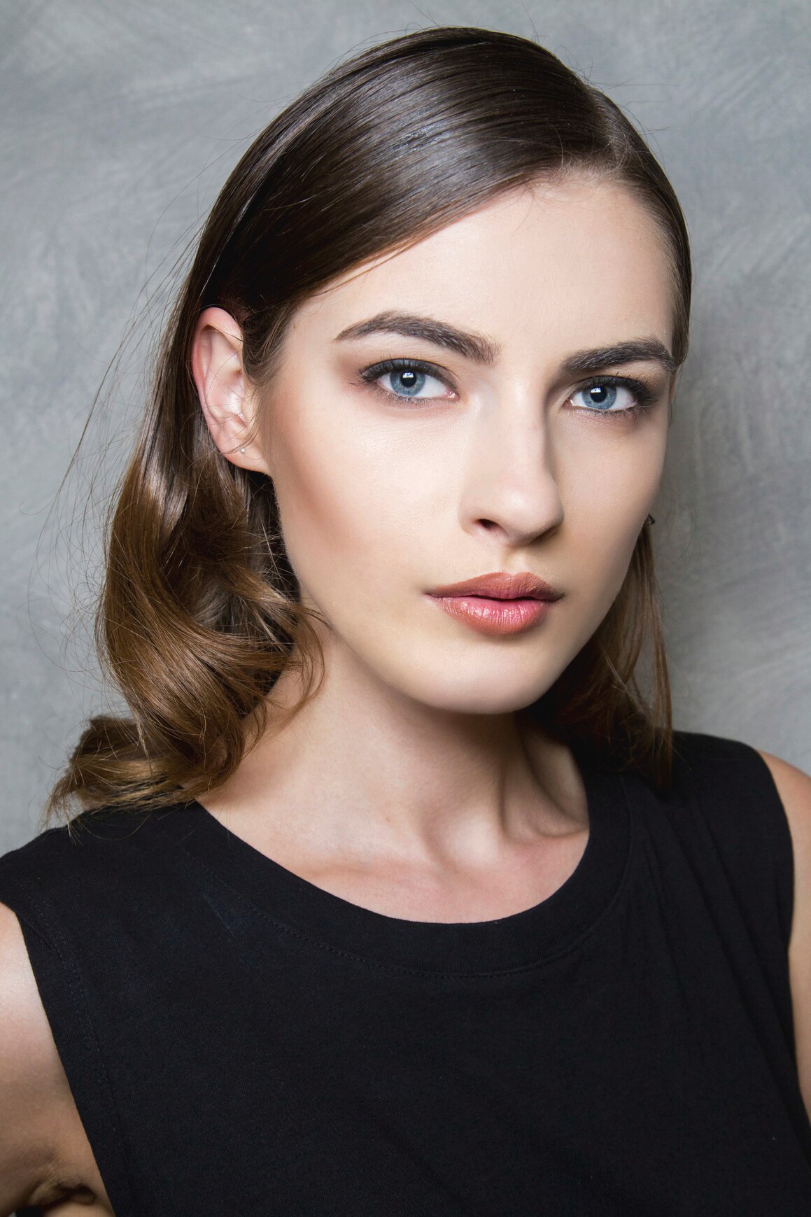 woman with platinum blonde hair in a pixie cut style using pins and clips to section her hair ready for styling