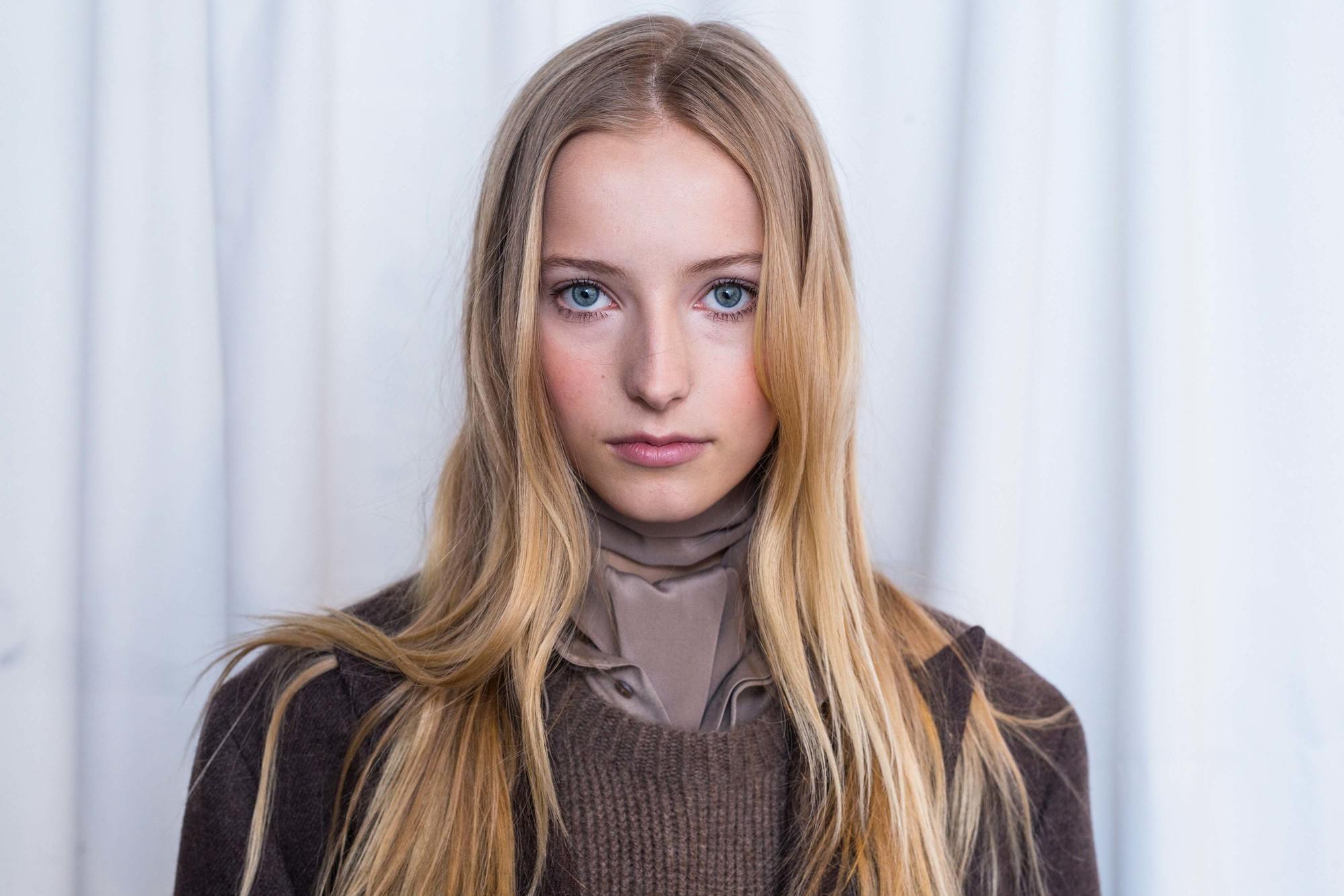 image of a woman with dark roots and wavy dirty blonde hair