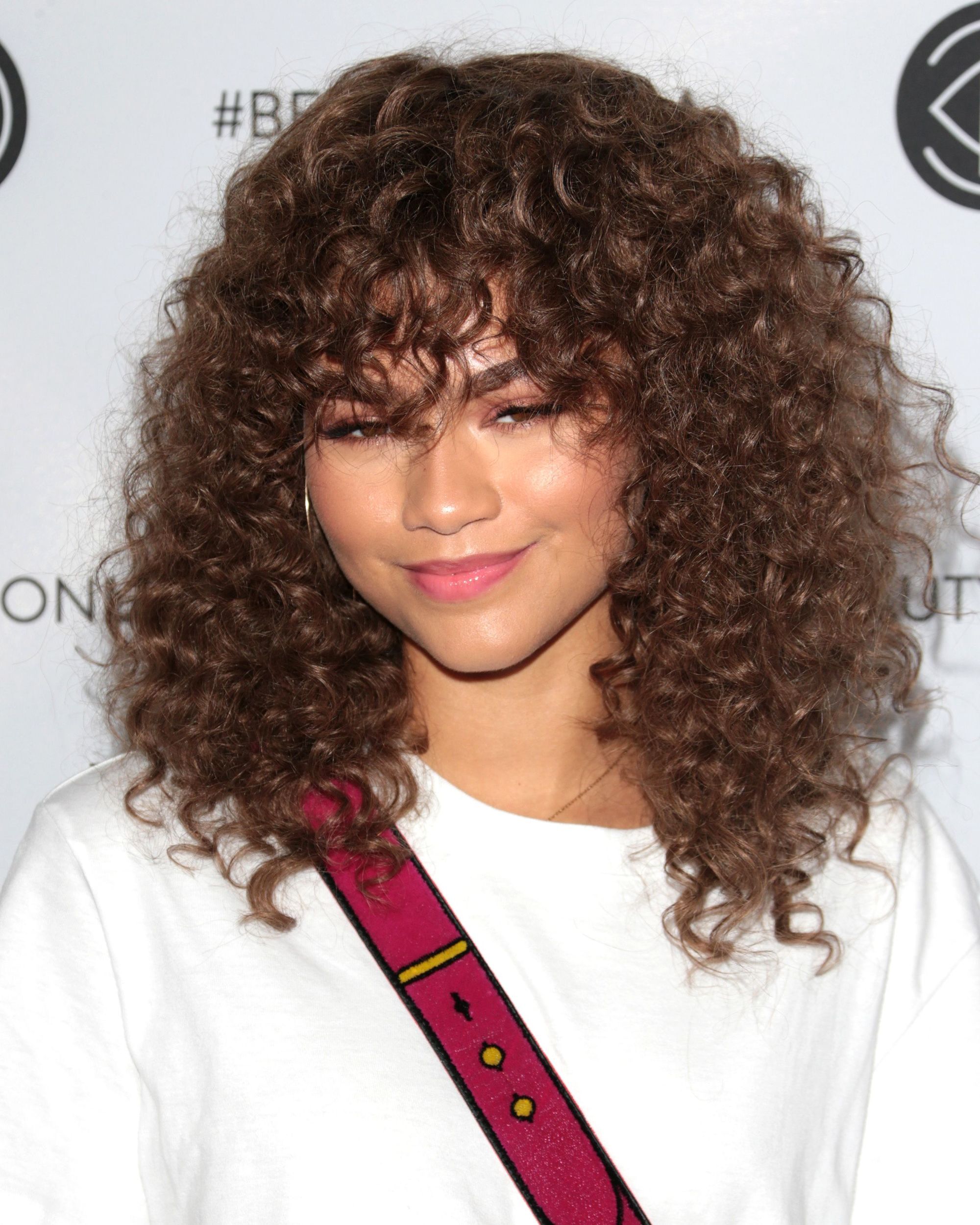 Gaya rambut keriting alami juga bisa menggunakan poni. (Foto: REX by Shutterstock)