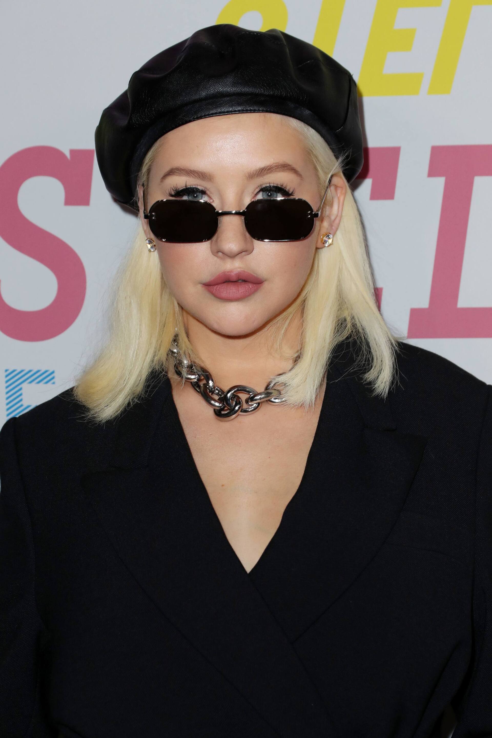 Turtleneck hair ideas: Woman with long, straight black hair with fringe, wearing a beret with a turtleneck and brown fur jacket
