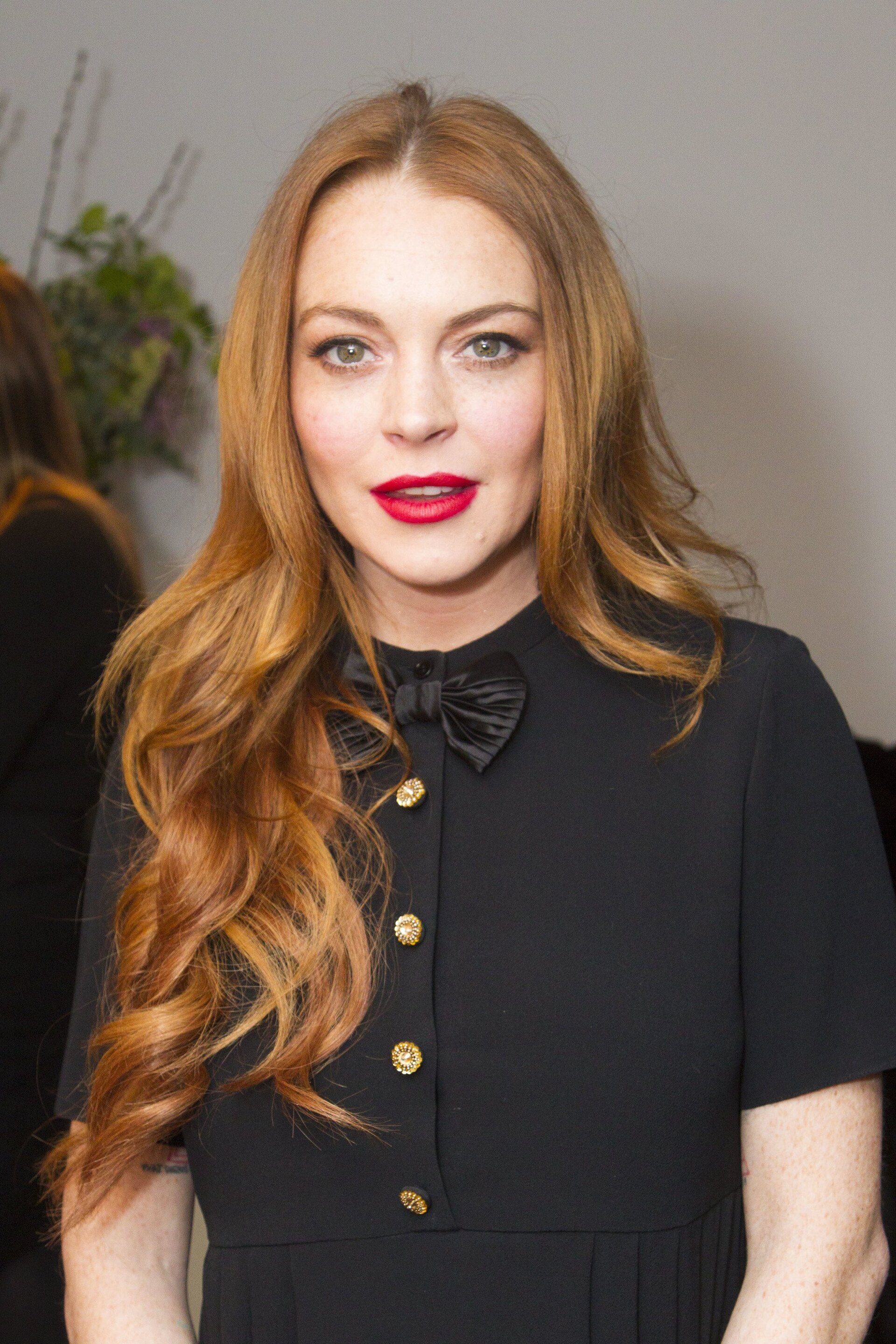 Famous redheads: Lindsay Lohan with long straight dark red hair wearing an all black outfit.