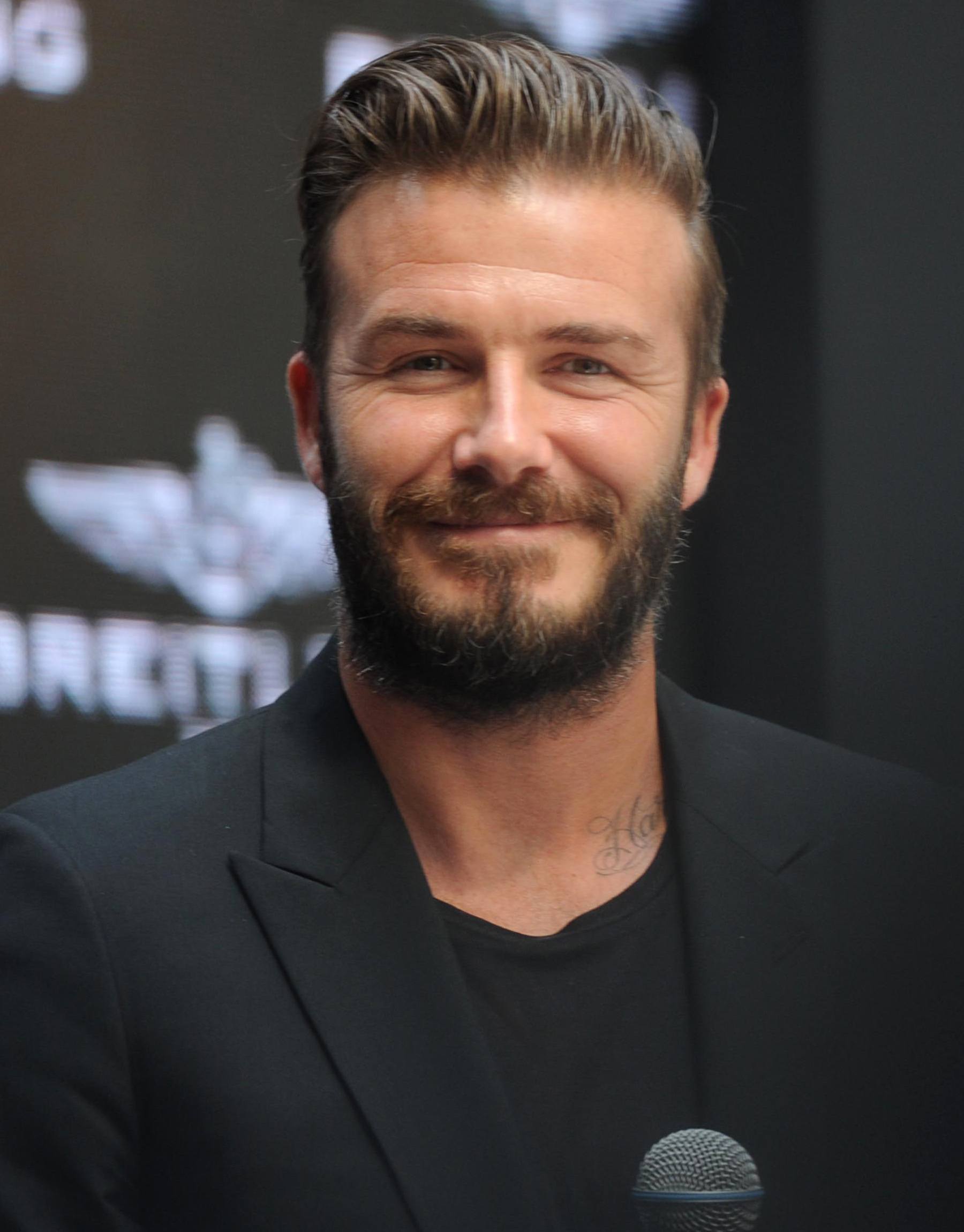 Hairstyles for receding hairline: Headshot of Chris Hemsworth with spiky crew cut hair, wearing a navy suit