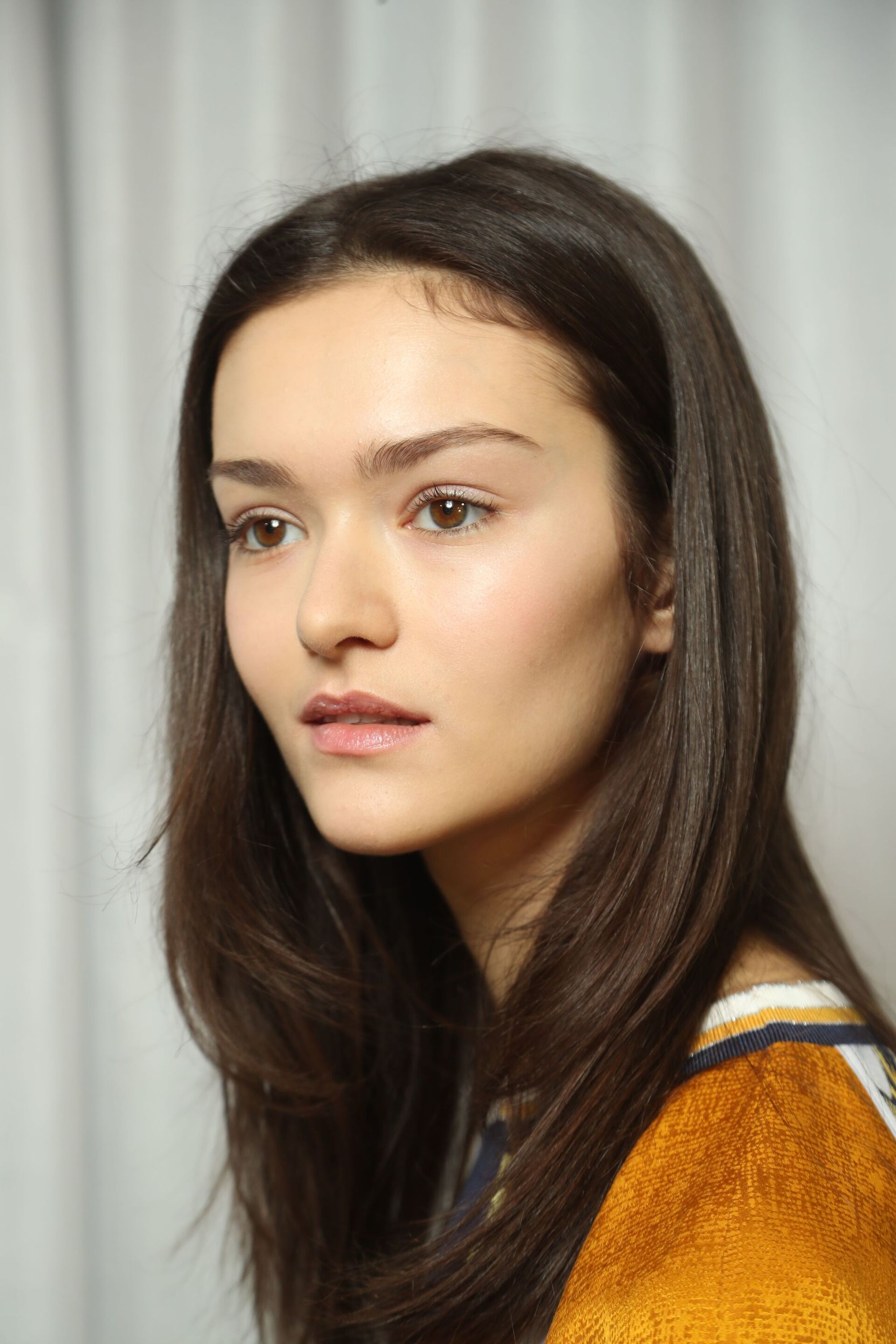 Asian hairstyles: Asian woman with dark brown wavy hair wearing a winter coat and scarf.