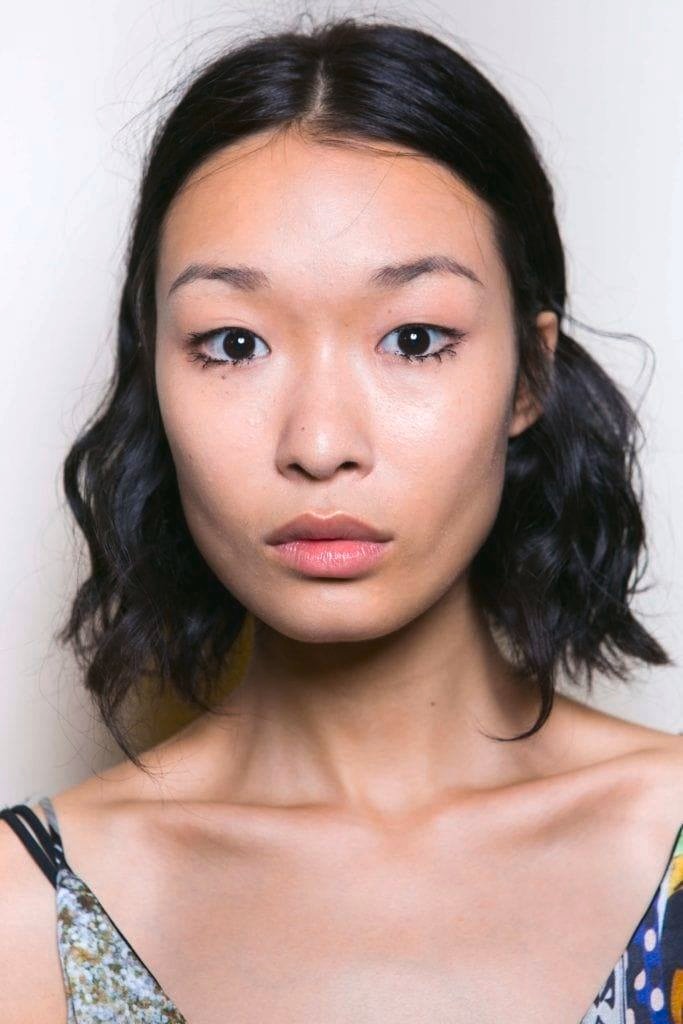 Asian hairstyles: Asian woman with dark brown wavy long bob.