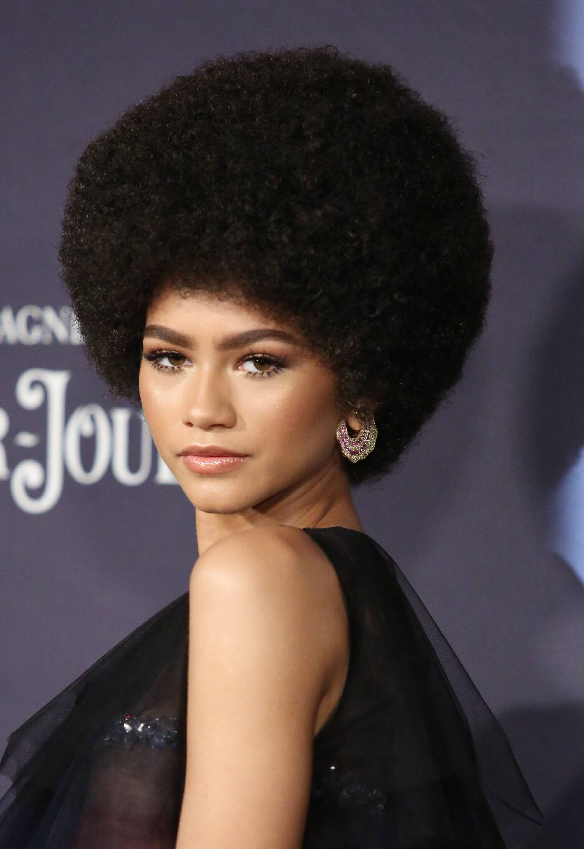 side view of a woman with dark slick back hair
