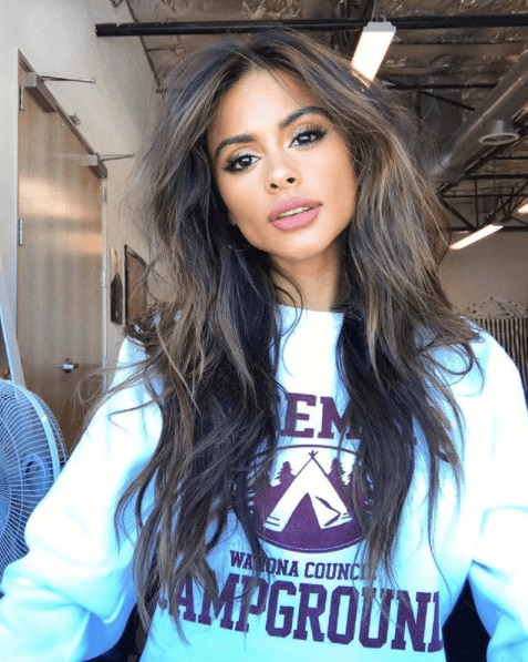 Brunette with medium length thick hair with face-framing layers