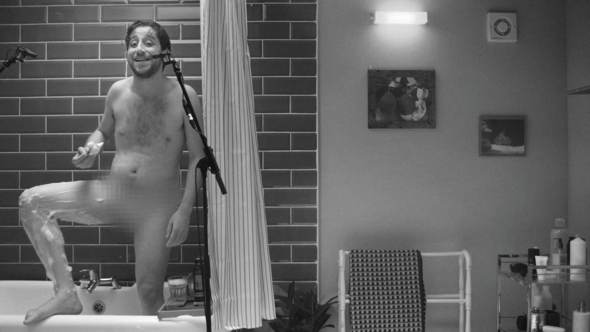 Man in shower shaving legs