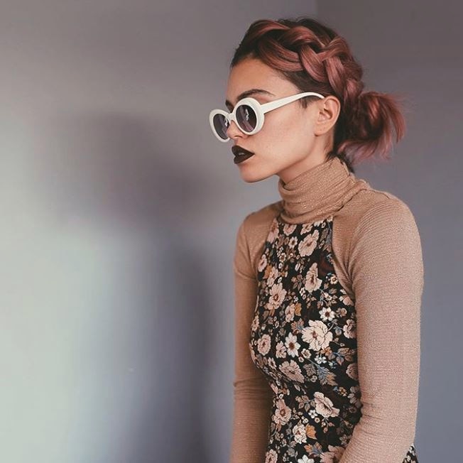 Blonde woman with straight hair in a low bun with side braid