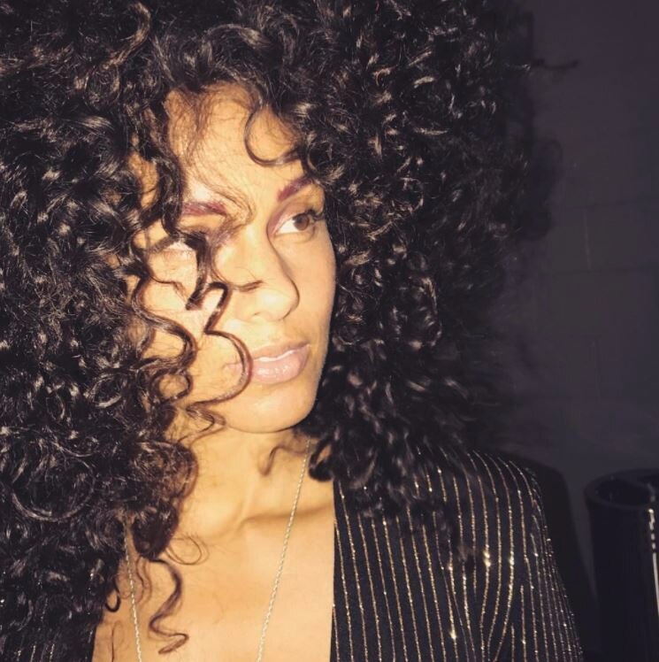 woman with natural curly hair and a fringe