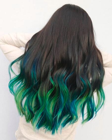 back view of woman with long wavy dark green ombre hair