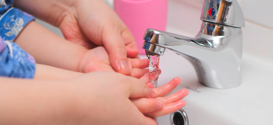 Person washing baby's hands