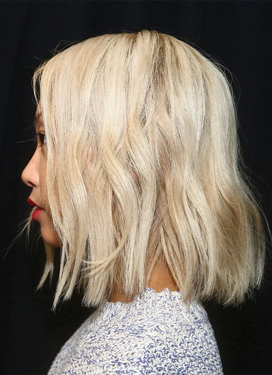 A stylist working on a model's hair backstage.