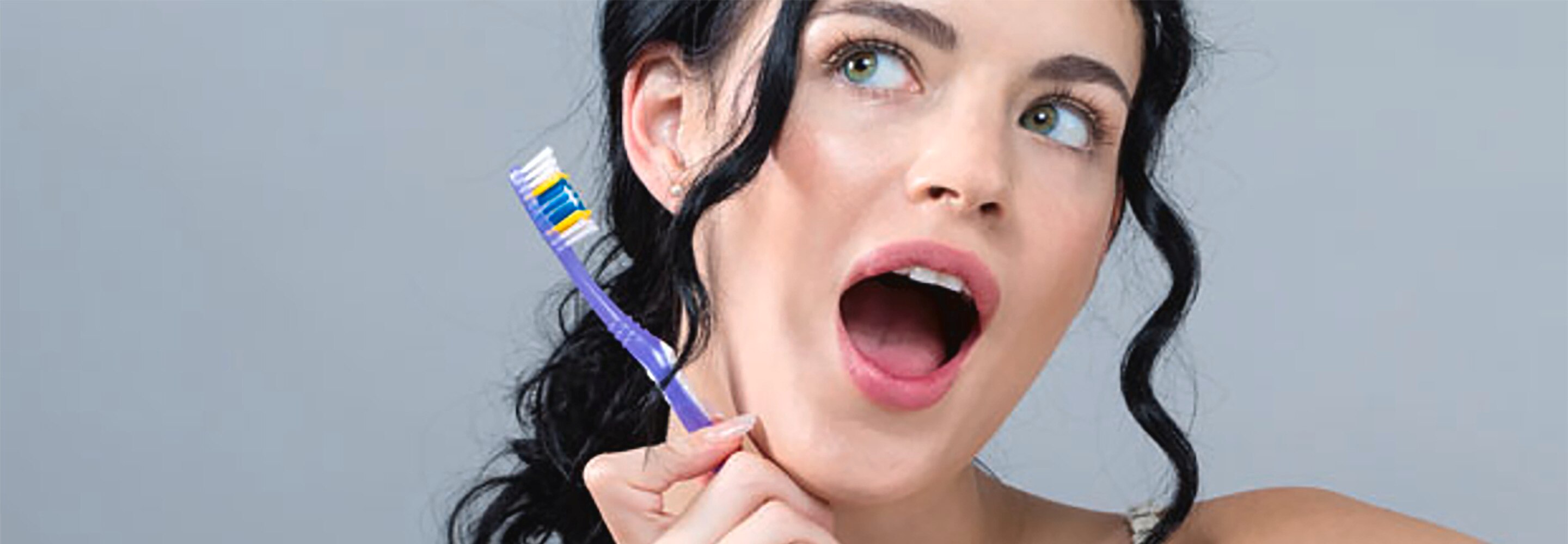 người phụ nữ cầm bàn chải đánh răng