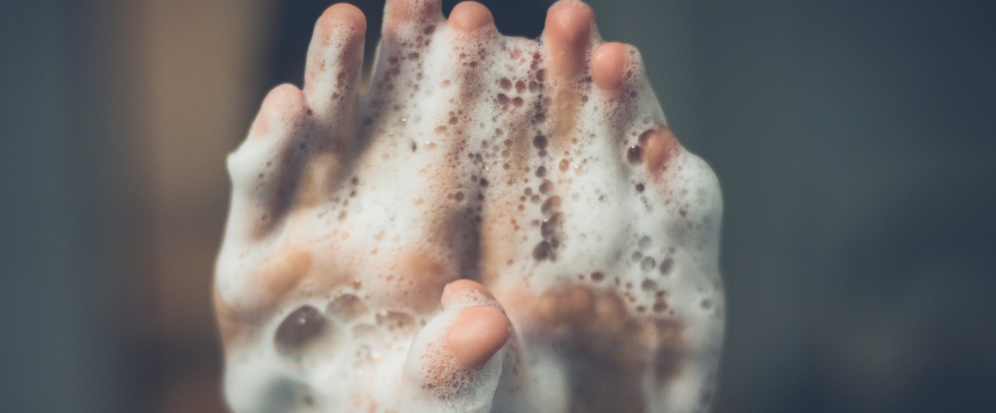 hands covered in foam being washed