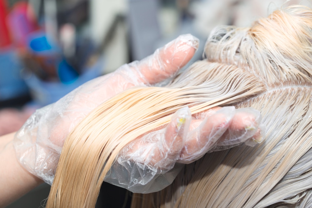 ผู้หญิง กำลัง ฟอกสีผม กัดสีผม