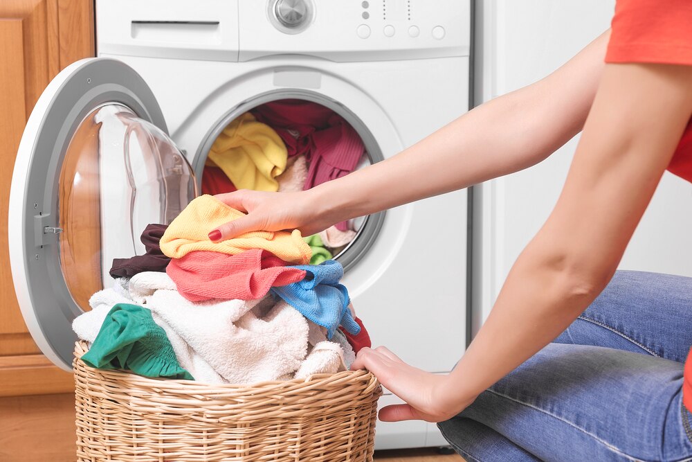 Woman preparing clothes to be washed in a washing machine