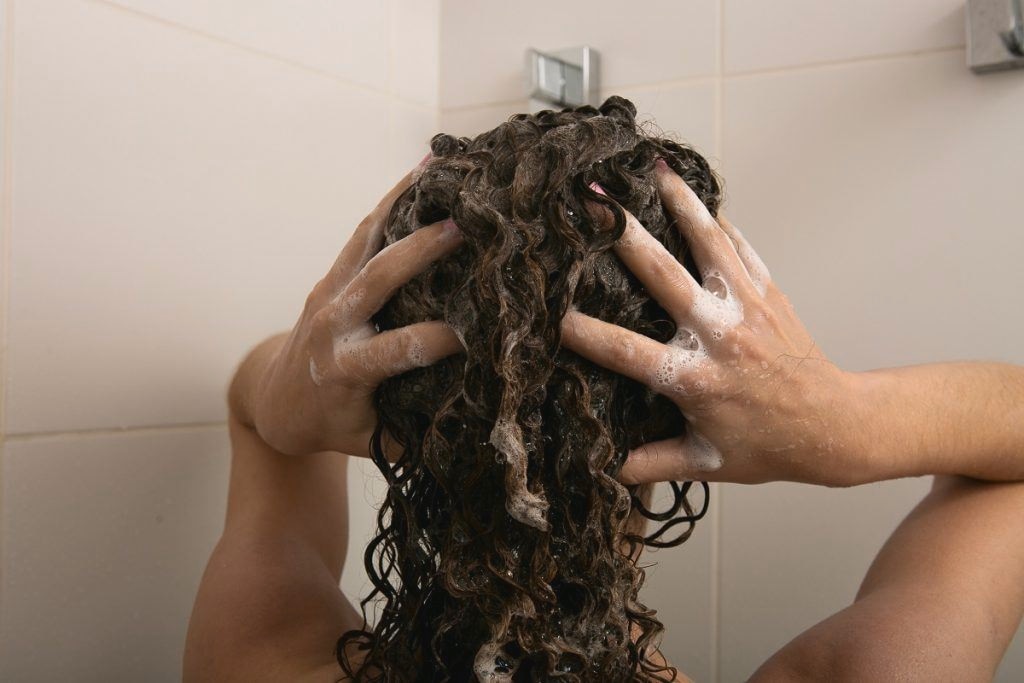 Woman washing her hair in a shower