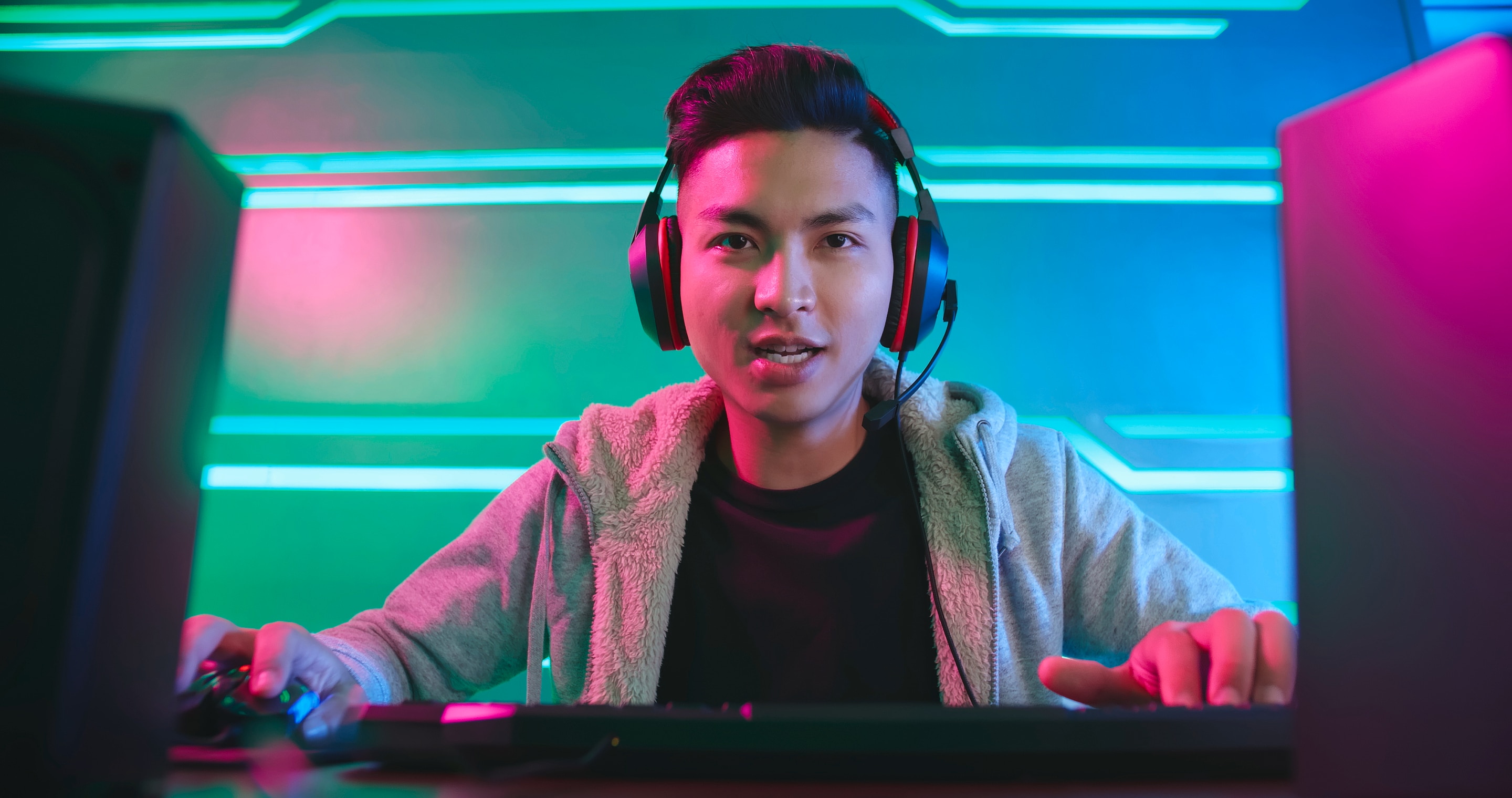 pria sedang menggunakan headphone dan bermain game di desktop