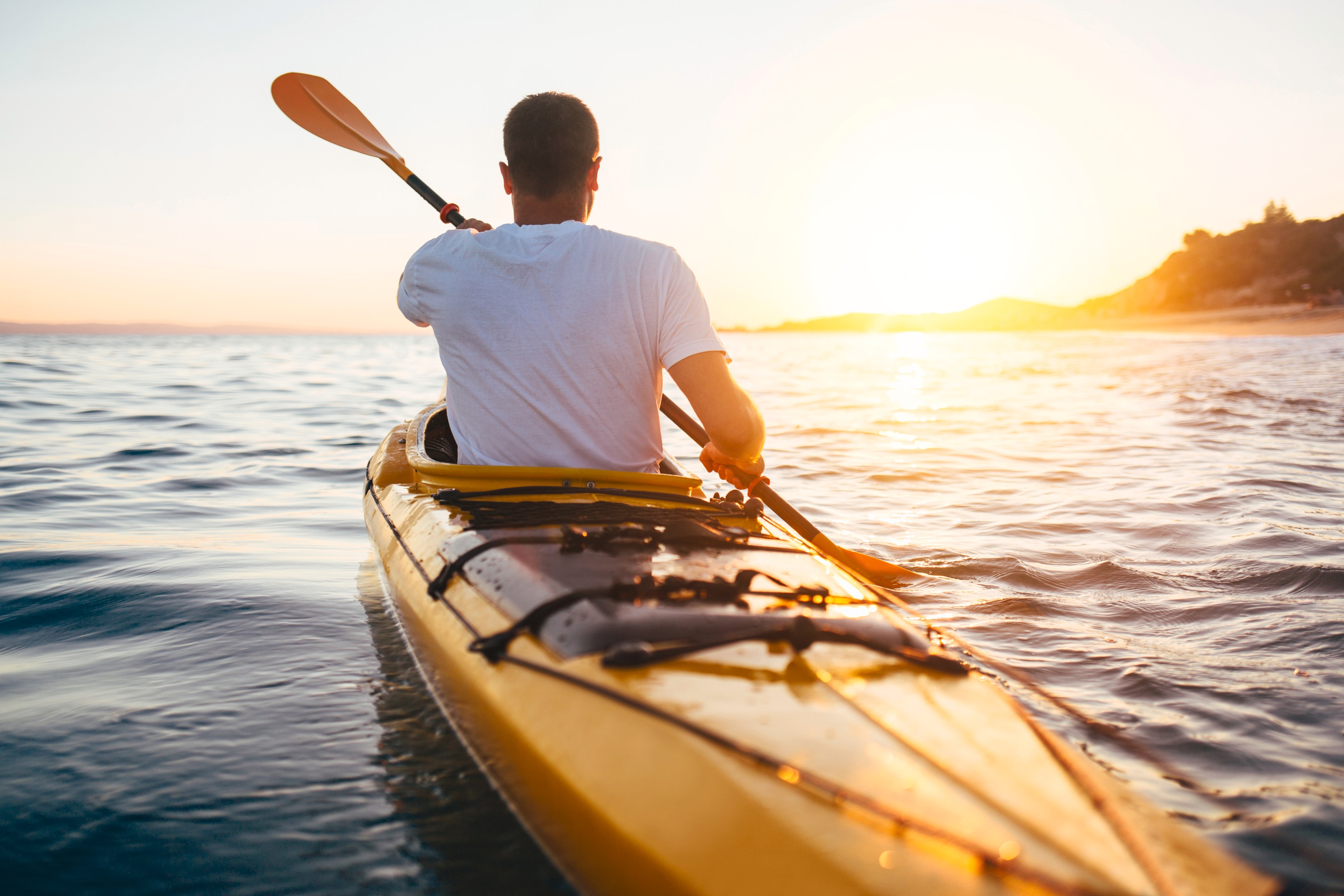 pria sedang mengayuh kano