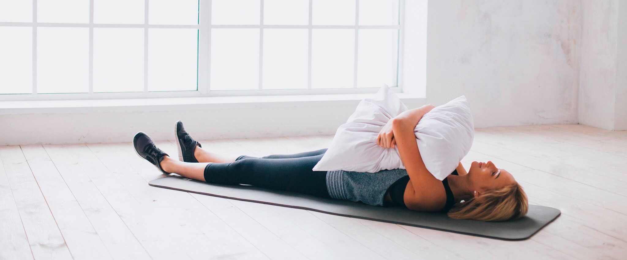 Women lying on yoga mat with a pillow