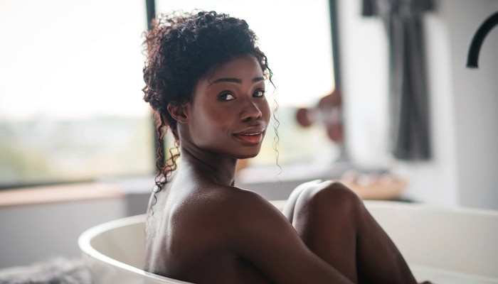 Beautiful African woman feeling good while taking a bath