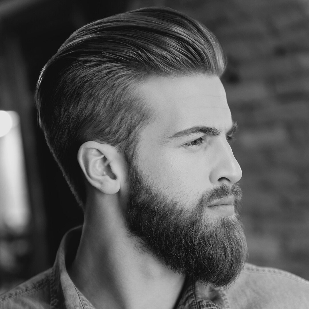 Un homme avec un anneau dans le nez, une boucle d'oreille et une coiffure dessous tondu
