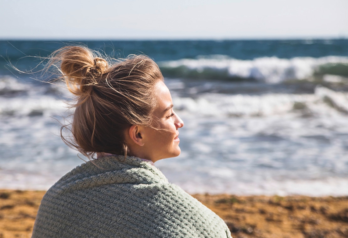 Image of Woman With Messy High Bun on Beach