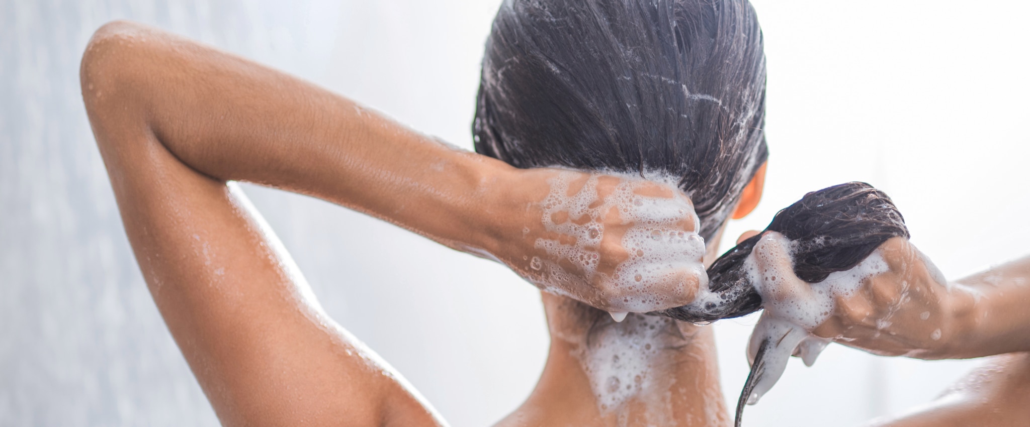 Woman lathering shampoo into hair