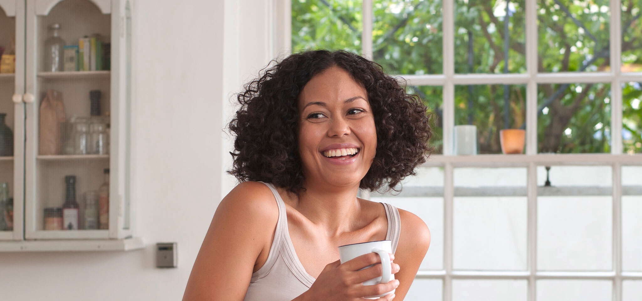 Woman with frizzy hair holding cup