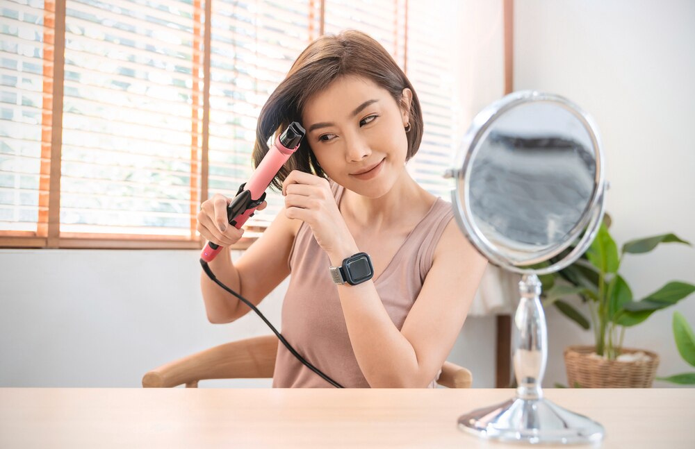 Asian woman using a curling iron