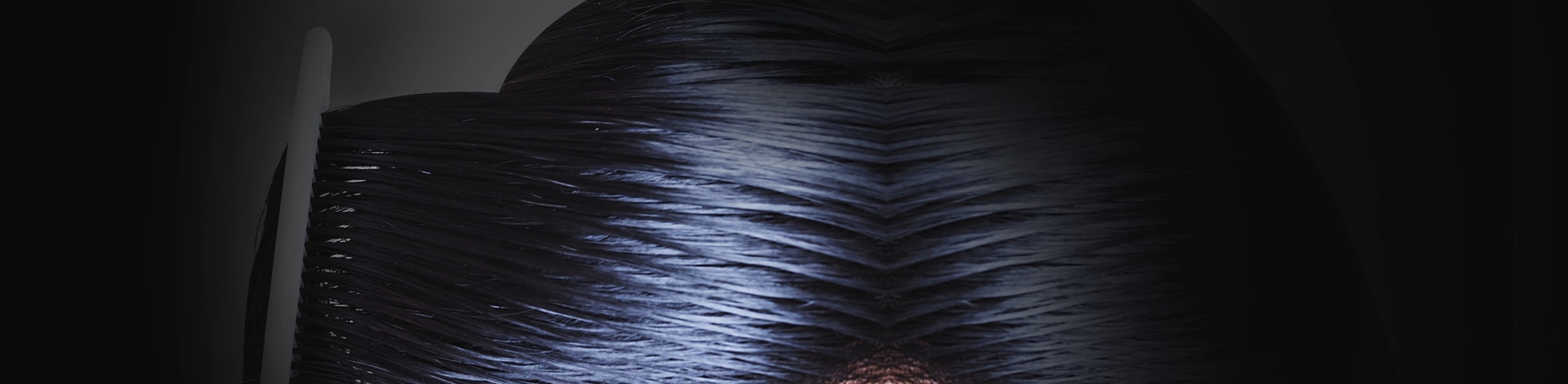 Closeup of sleek black hair being combed