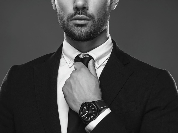 Teaser con el primer plano del saco de un traje, la camisa y la corbata de un hombre.