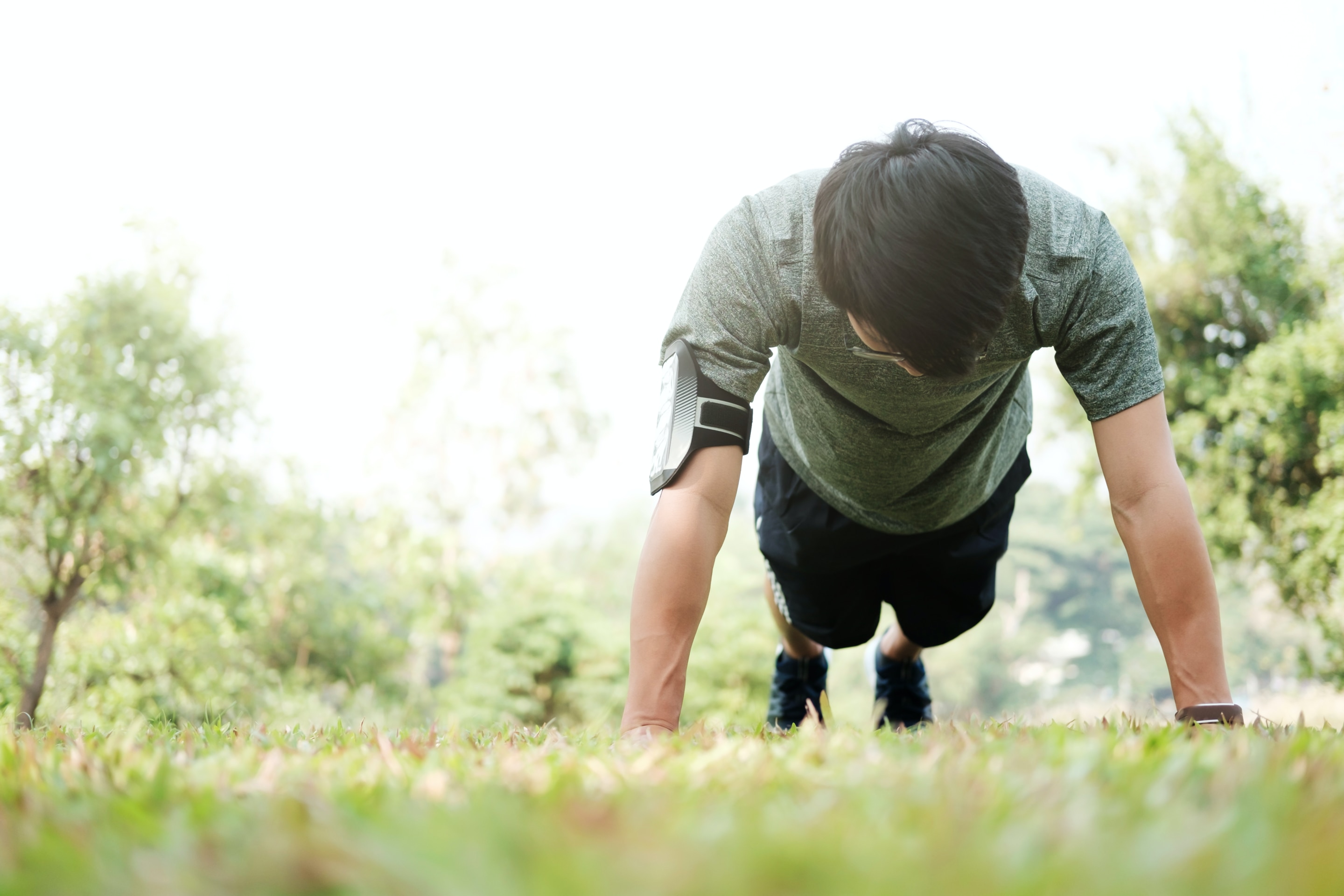 pria sedang melakukan gerakan workout di rumah berupa push up