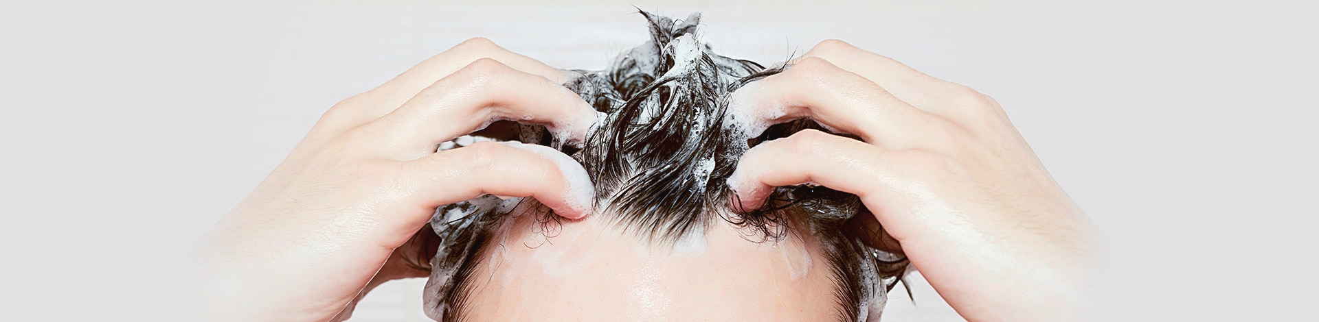 Homem massageando o couro cabeludo no banho