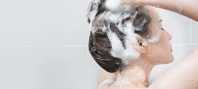 Women in washing hair in shower