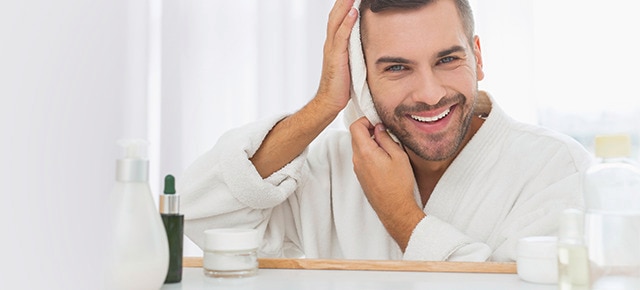 Guy drying hair with towel in mirror