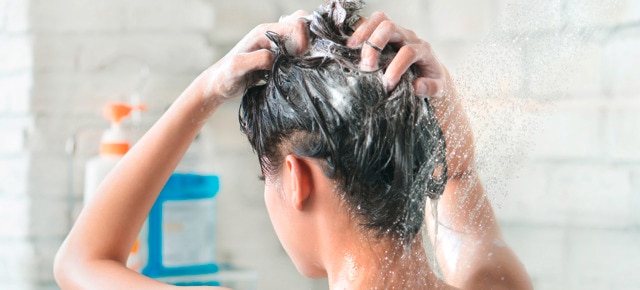 Mulher lavando o cabelo no chuveiro