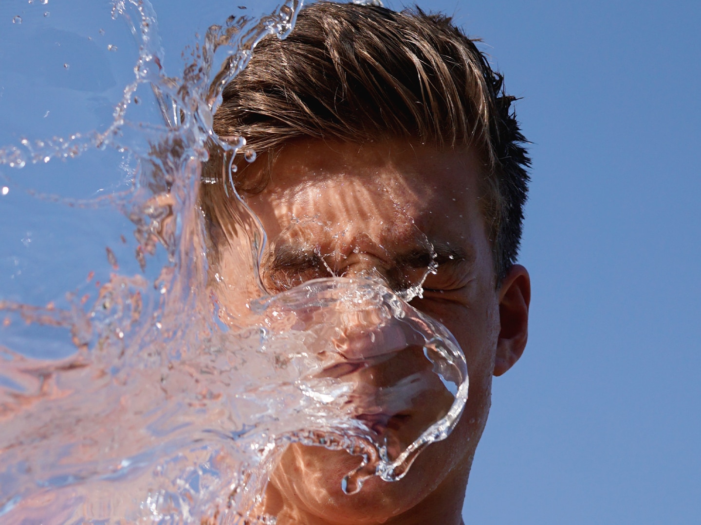 a guy splashing water into his own face