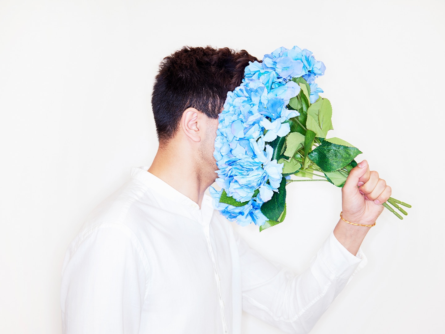 A guy smelling flowers 