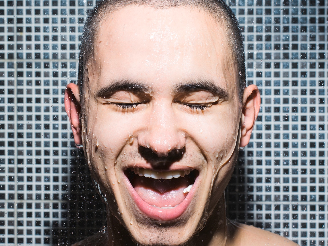 Närbild på killens ansikte i duschen