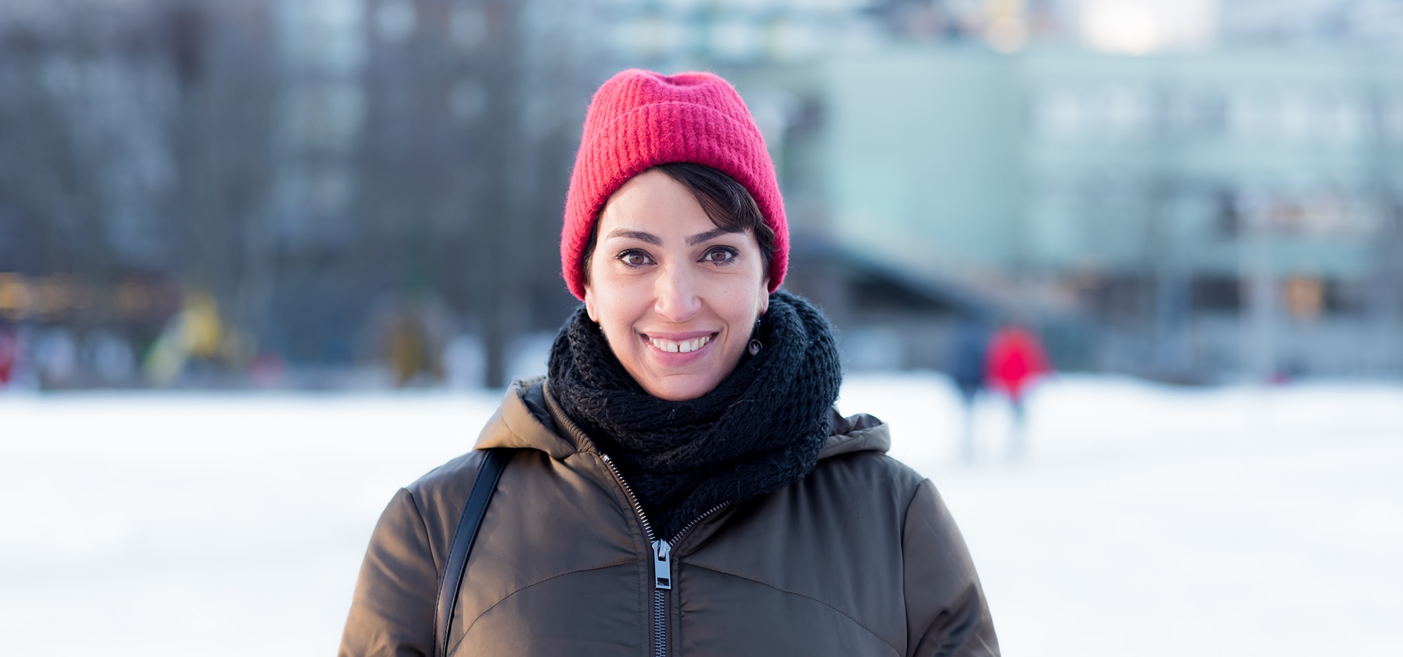 woman wearing a beanie smiling directly at the camera