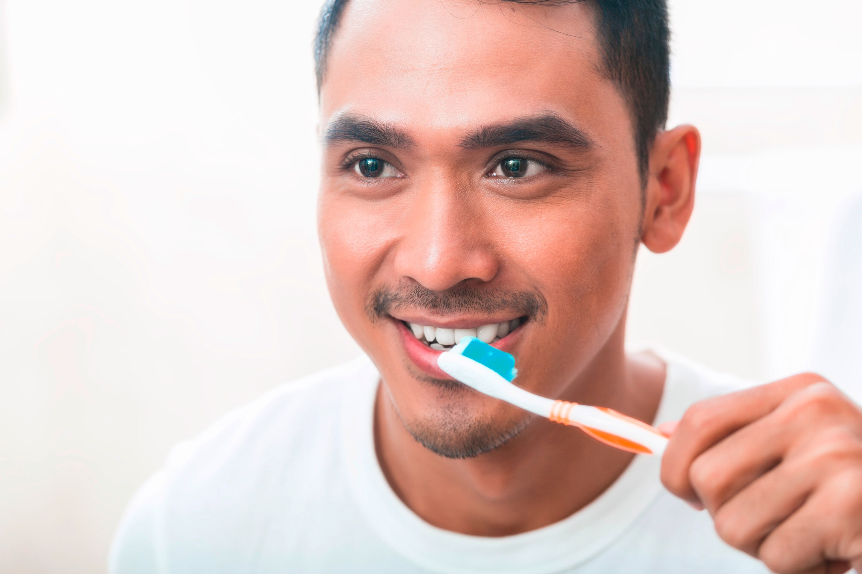 Asian man brushing teeth