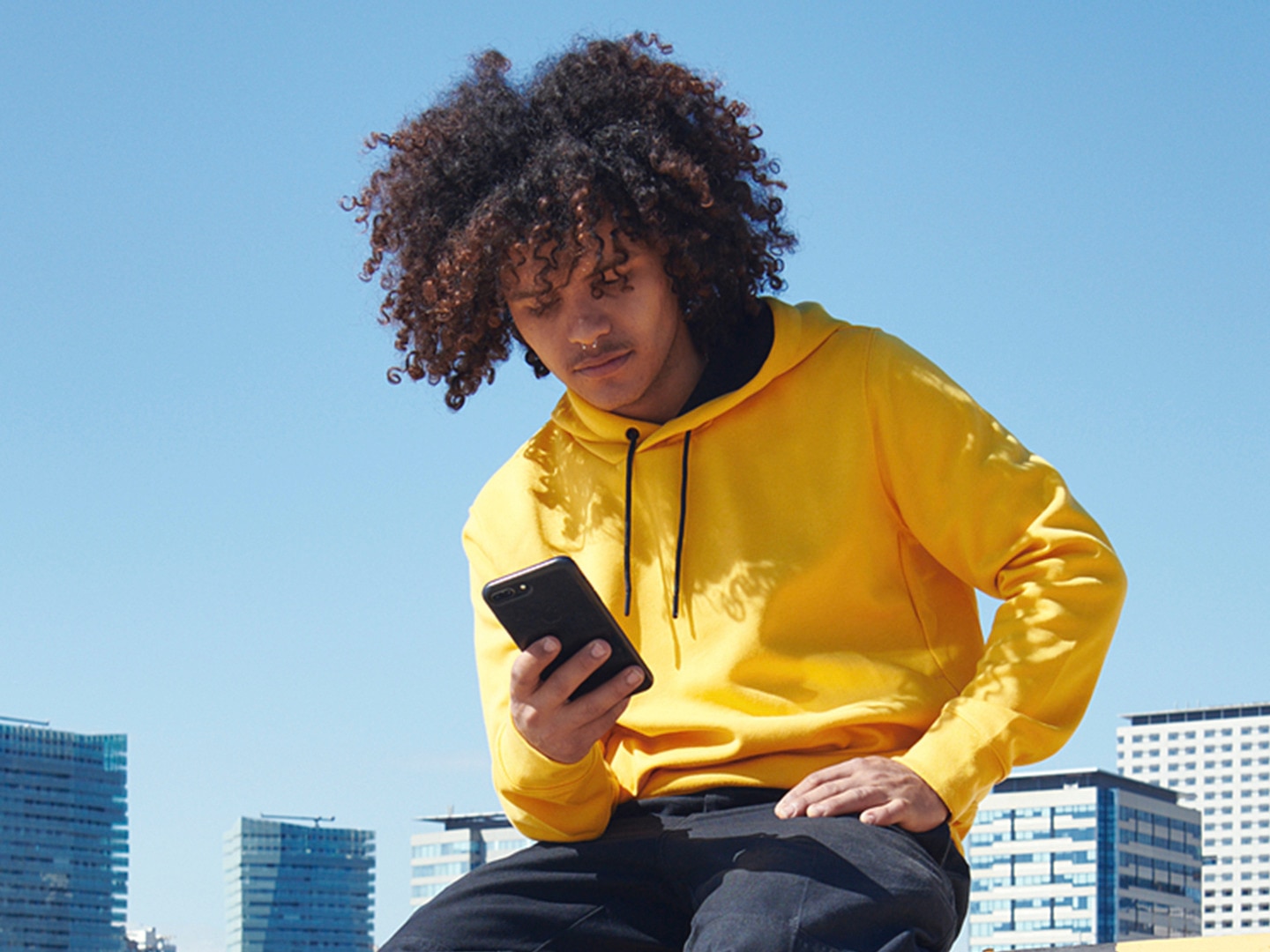Guy in yellow hoodie looking at phone