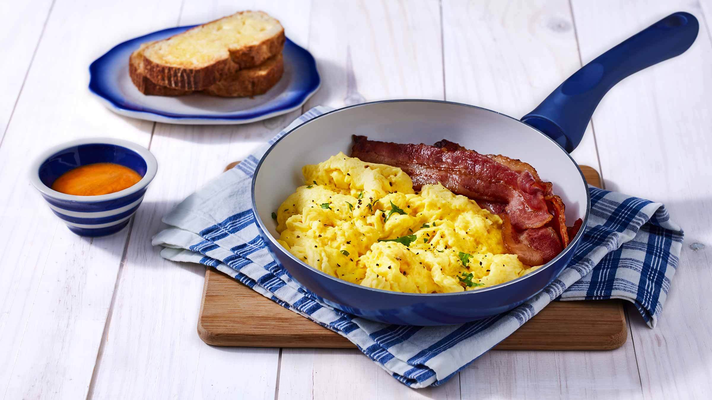 scrambled eggs and bacon in a pan