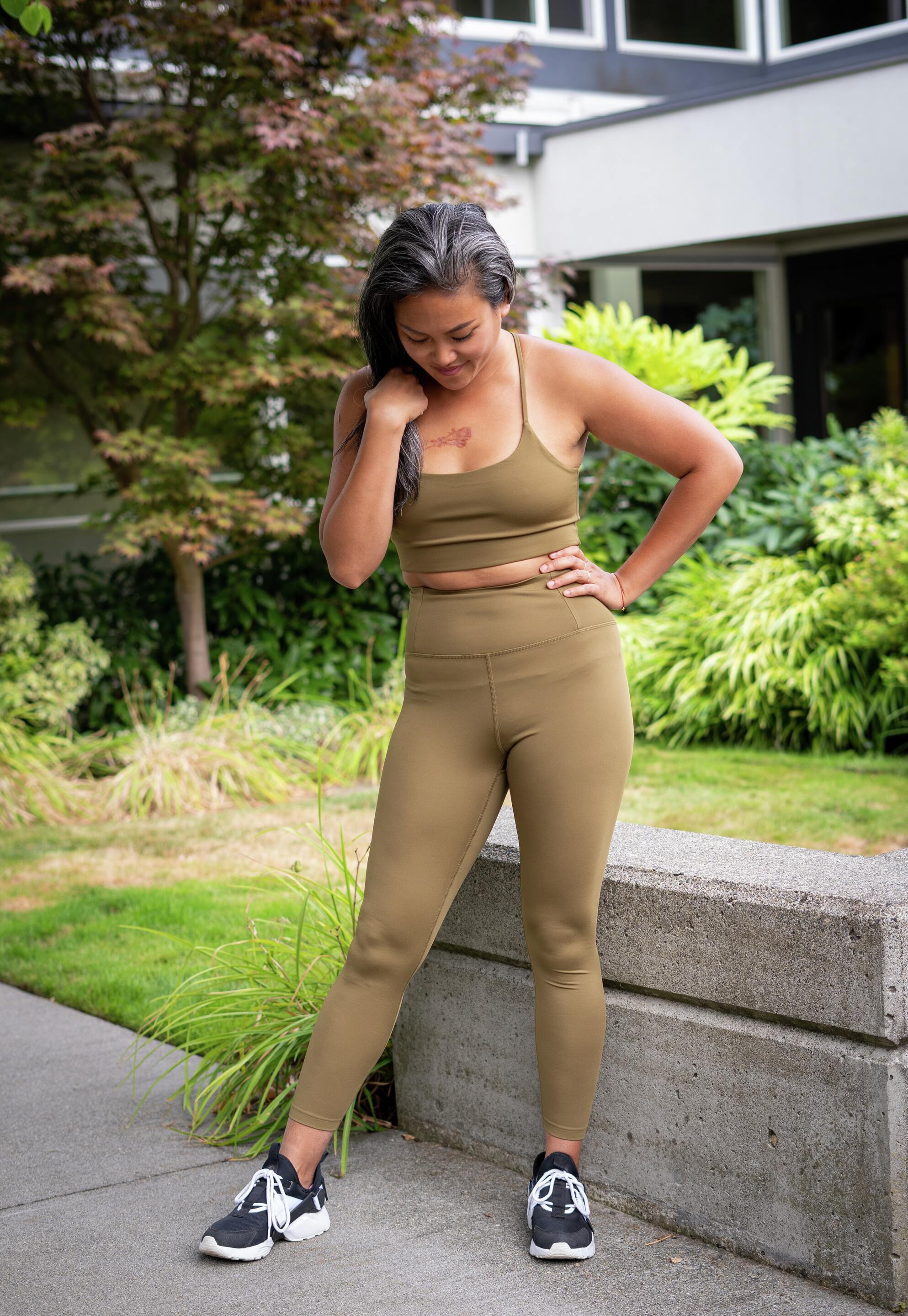 Woman in green gym gear looking at her feet